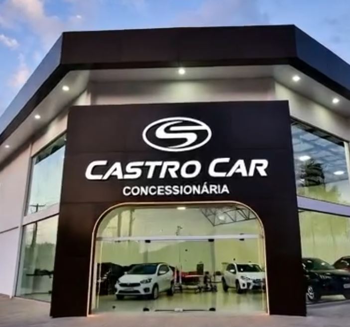 Fachada noturna da Castro Car Concessionária em ACM preto com letra caixa branca iluminada