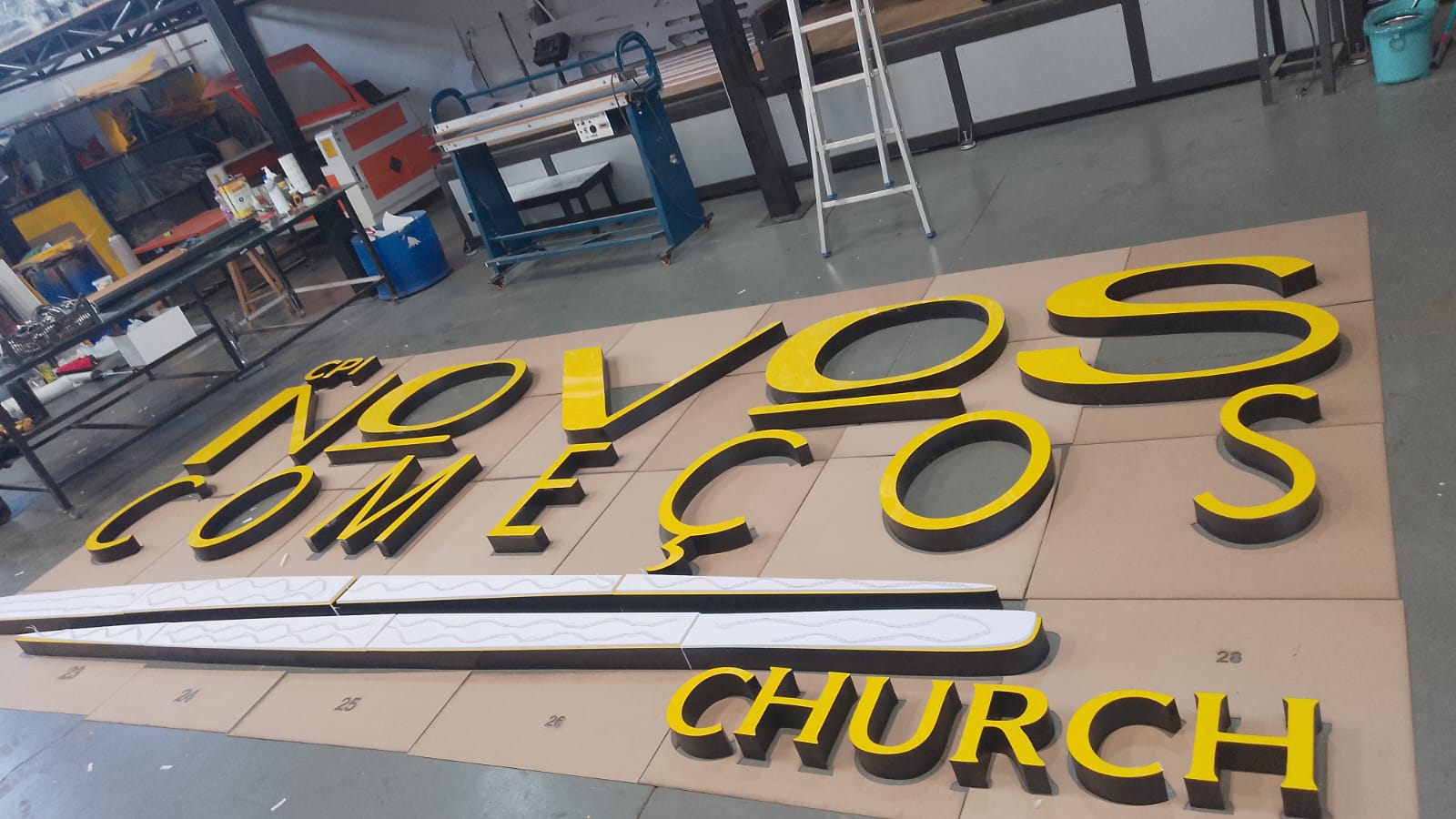 Letras caixa da Novos Começos Church em produção na oficina, em amarelo e preto
