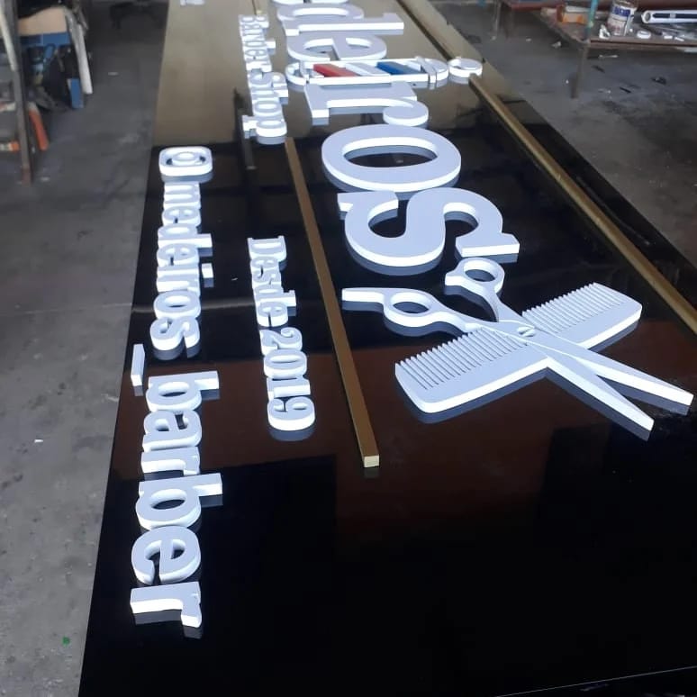 Letras caixa em PVC branco do Medeiros Barber Shop sobre base preta em produção