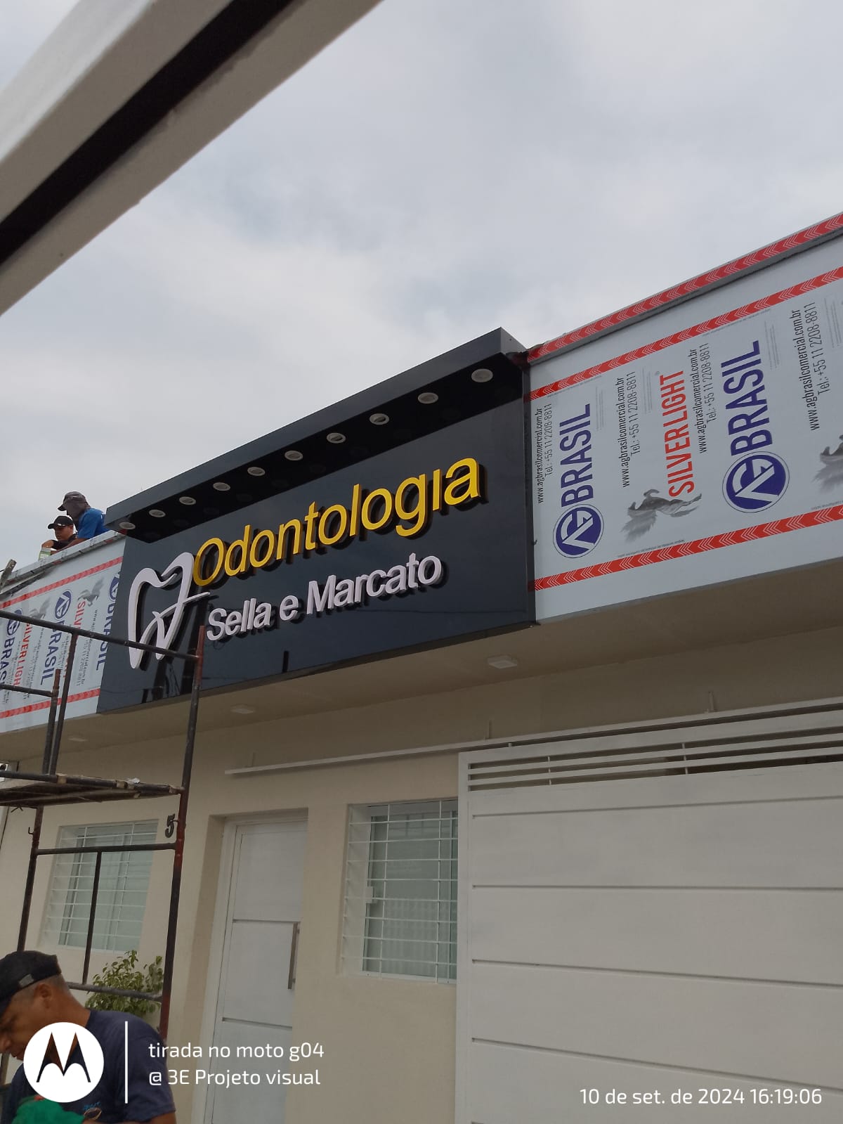 Painel luminoso Odontologia Sella e Marcato durante instalação na fachada