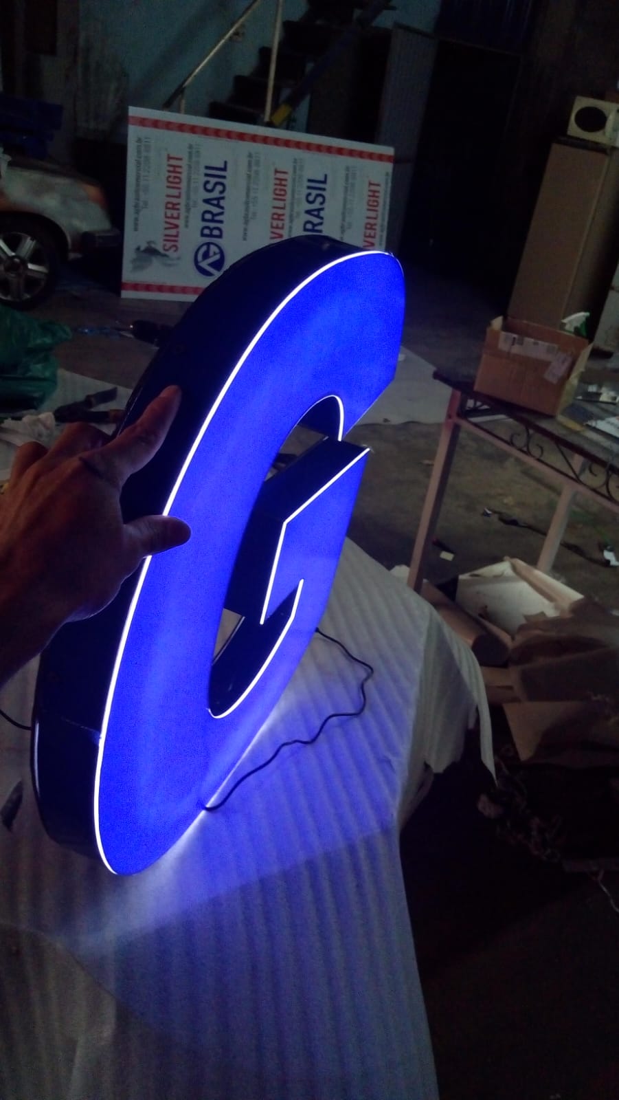 Letra caixa G com efeito backlight azul em produção
